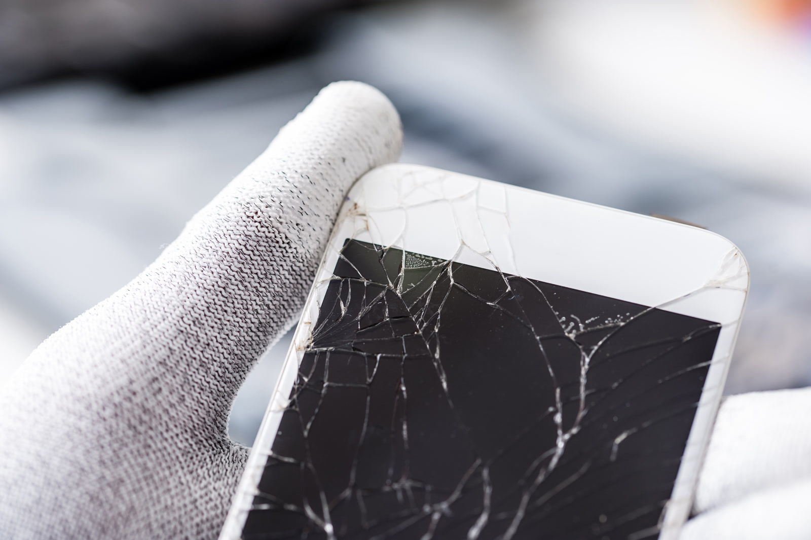 Technician holding a phone with a broken screen